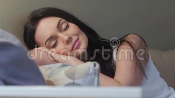 美丽的黑发女人在家里的沙发上睡着了视频的预览图