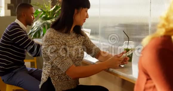 女士在喝果汁4k的同时使用数码平板电脑视频的预览图