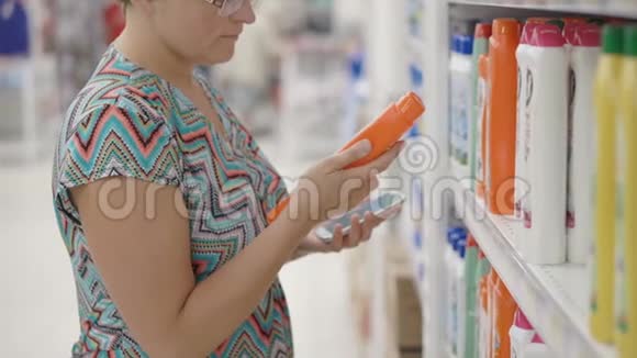 女人用手机选择超市里的家用产品视频的预览图