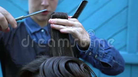在户外实验理发店中女理发师剪的奇怪中年嬉皮士男子视频的预览图