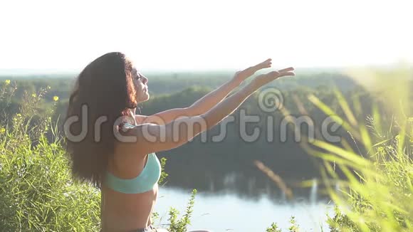 健康的女人在日落时在摆莲花慢动作视频的预览图