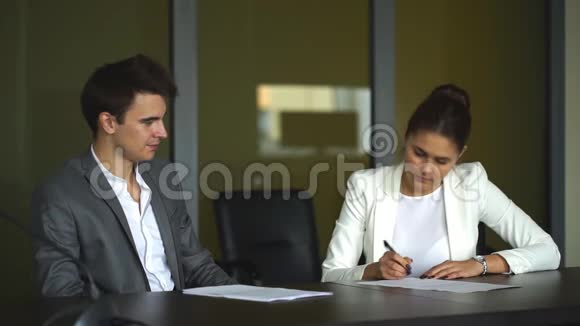 可爱的女商人让他的客户在会议上签署合同并完成交易视频的预览图