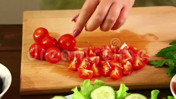一个女人正在切樱桃西红柿做蔬菜沙拉特写视频的预览图