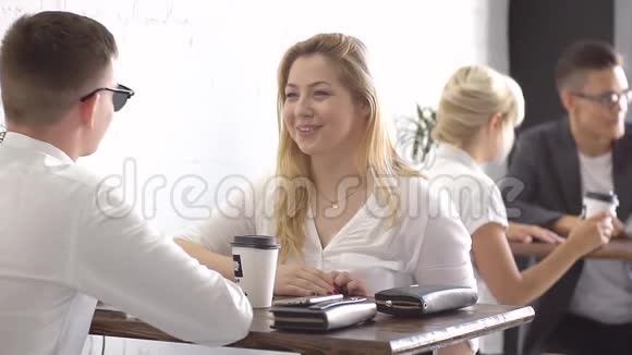 快乐的创意团队在休息时喝咖啡在办公室里进行讨论视频的预览图