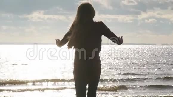 海滩上的女孩举起手臂飞向天空视频的预览图