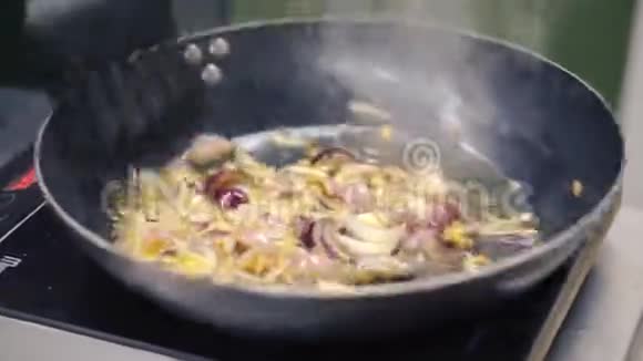 在煎锅里煮洋葱剪辑在铸铁锅中煎洋葱视频的预览图