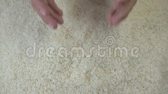 手中的米粒从一个人手中倒出未加工的大米视频的预览图