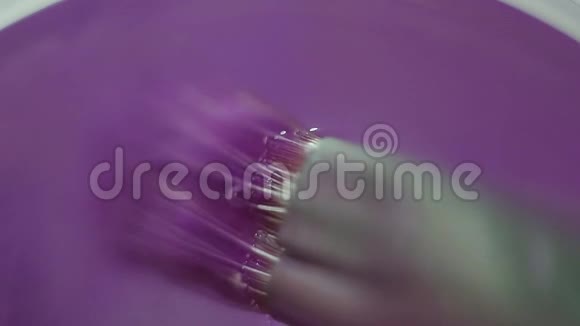 漆笔用紫色颜料浸入水杯中视频的预览图