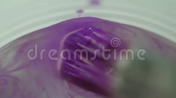 用紫色油漆蘸水玻璃的画笔视频的预览图