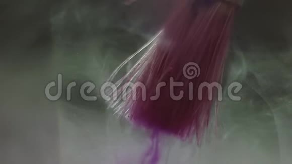 漂亮的紫色油漆在液体中漂浮着刷子视频的预览图