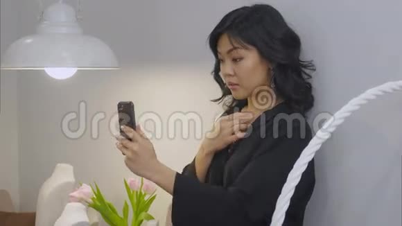 美丽的黑发女人用智能手机拍下了自己戴着新项链的照片视频的预览图