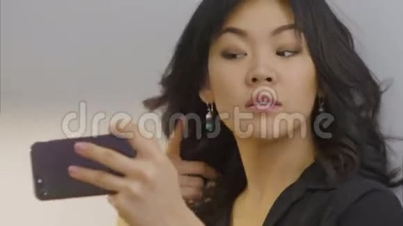 亚洲女人用智能手机理发视频的预览图