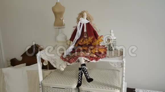 一个漂亮的洋娃娃坐在有枫树枝的架子上视频的预览图