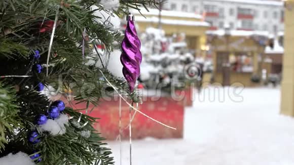 圣诞树上覆盖着雪上面装饰着球和玩具在街上有一场暴风雪在里面视频的预览图