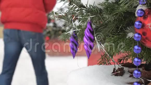 圣诞树上覆盖着雪上面装饰着球和玩具在街上有一场暴风雪在里面视频的预览图