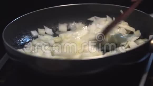 切好的洋葱放在锅里的植物油里炒厨房瓷砖上的特写洋葱炒黄油视频的预览图
