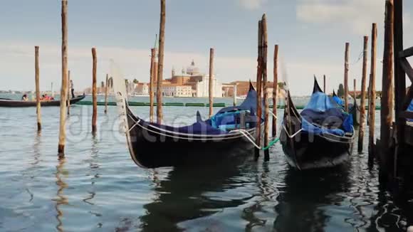 威尼斯的象征是传统的贡多拉船波浪上的岩石停泊在岸边视频的预览图