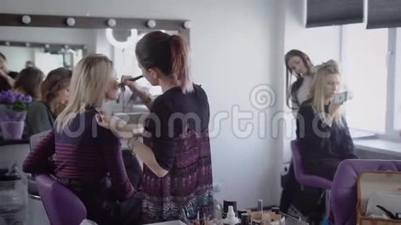 著名美容店的化妆师和理发师正在与两个模特合作为未来的拍摄做准备视频的预览图