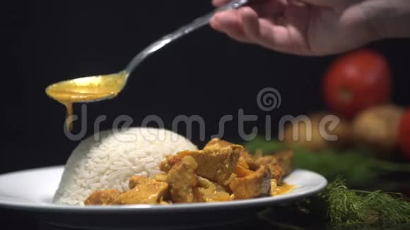 咖喱鸡汤伊纳店菜蒸饭厨师在蒸饭中加入咖喱鸡放在黑色的盘子里视频的预览图