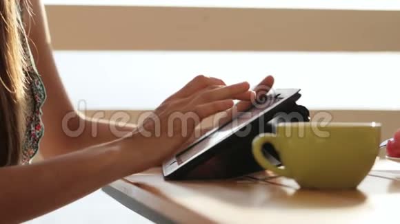 在露天咖啡馆用平板电脑特写女性的手视频的预览图