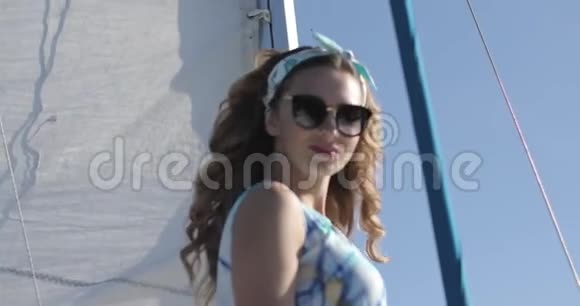 夏天在游艇上摆着太阳镜的漂亮女孩风吹卷发视频的预览图