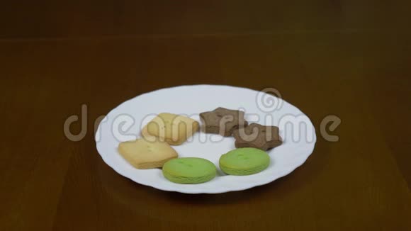 用姜饼把白色盘子的小娃娃合上自制饼干放在桌子上的盘子里去追踪视频的预览图