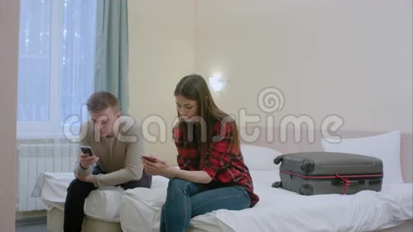 夫妻俩坐在床上吵架后不和对方说话在智能手机上打字视频的预览图