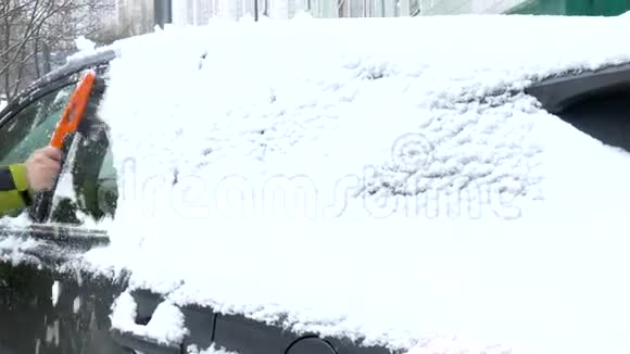 人们在大雪后从汽车挡风玻璃上擦雪视频的预览图