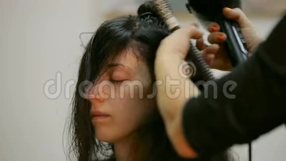 美容和人的概念幸福的年轻妇女与理发师造型头发与吹风机在美发店视频的预览图