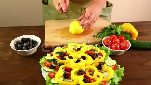 一个女人切了一个柠檬把它的果汁挤成一个盘子和一个蔬菜沙拉特写镜头视频的预览图