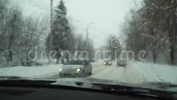 汽车沿着雪道行驶暴风雪视频的预览图