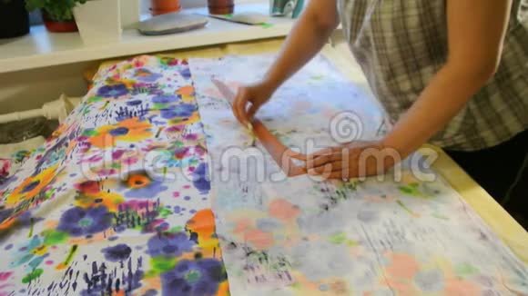 女裁缝用粉笔在布料上画画创造服装的过程视频的预览图