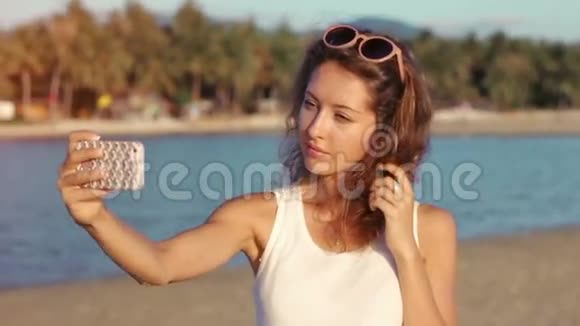 快乐的年轻女子在海边海滩自拍视频的预览图