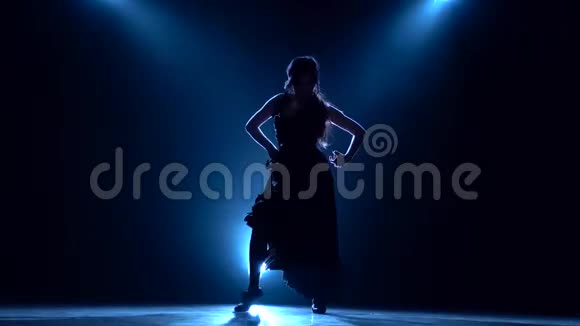 女孩正在黑暗的房间里跳舞从后面发光烟雾背景剪影视频的预览图