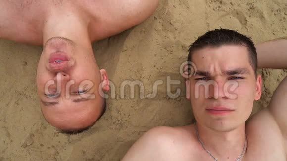 还有两个年轻人躺在海滩上嚼口香糖吹泡泡对着镜头微笑视频的预览图