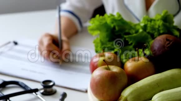 营养学家在满桌的水果和蔬菜上写饮食计划视频的预览图