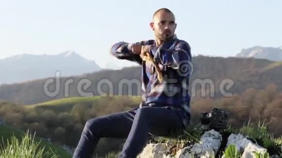 一个秃头英俊的人在美丽的山景中吃面包视频的预览图