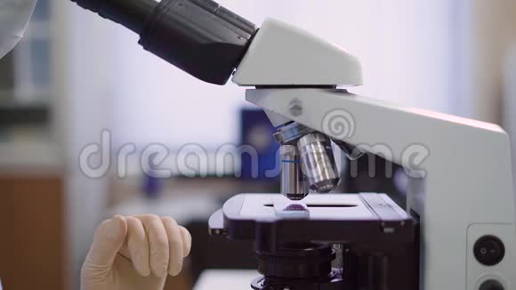女医务人员带着显微镜在实验室她正在研究血液测试或生物涂片是的视频的预览图