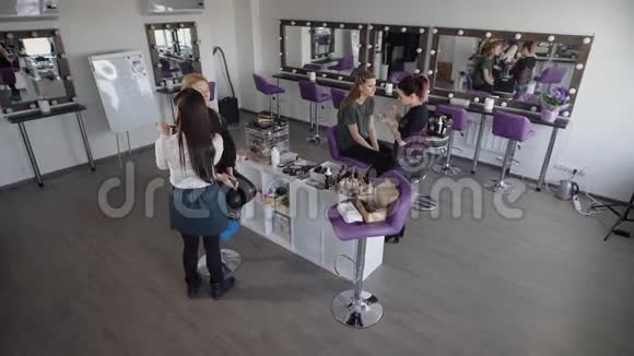 化妆师的美容博客美容店的两个女朋友化妆师训练两个女孩进行视频拍摄视频的预览图