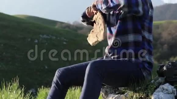 一个秃头英俊的人在美丽的山景中吃面包视频的预览图