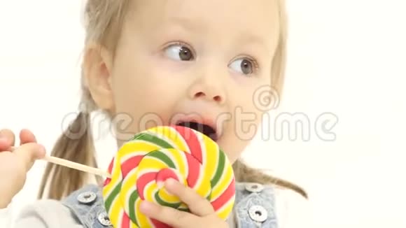 孩子手里拿着一颗甜糖舔它白色背景关门视频的预览图