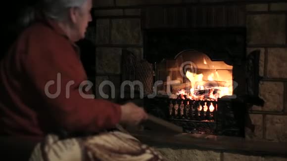 老人把木柴扔进壁炉视频的预览图