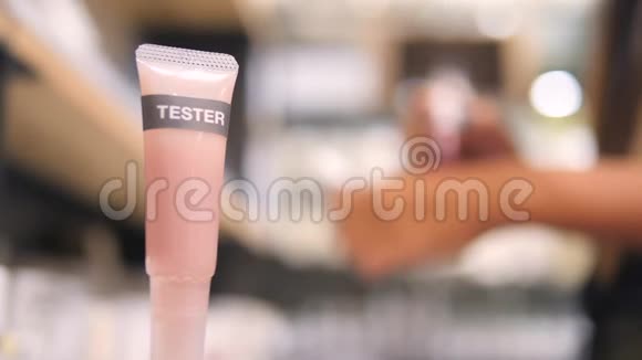 女人选择唇膏的颜色和尝试在她手上的化妆品超市在购物中心4K视频的预览图