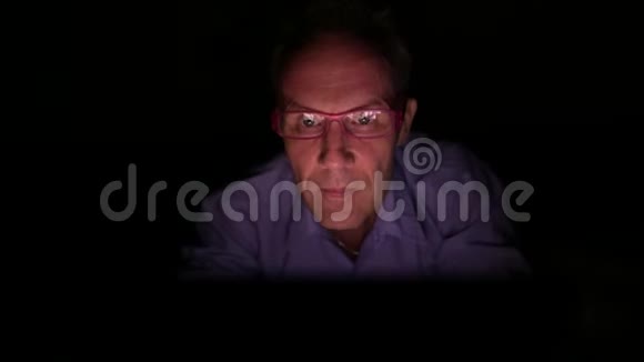 成熟的斯堪的纳维亚人在黑暗的房间里使用数字平板电脑视频的预览图
