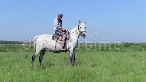 骑着白马的牧羊人看着摄像机视频的预览图