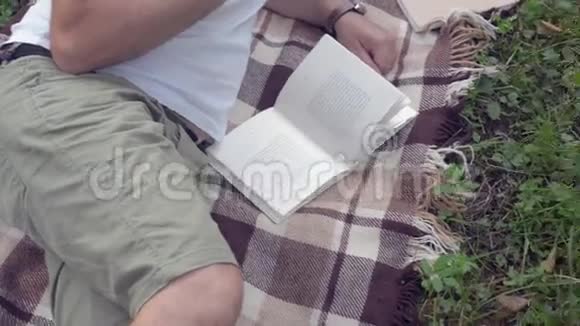 一个英俊的男人在草地上有一本书视频的预览图