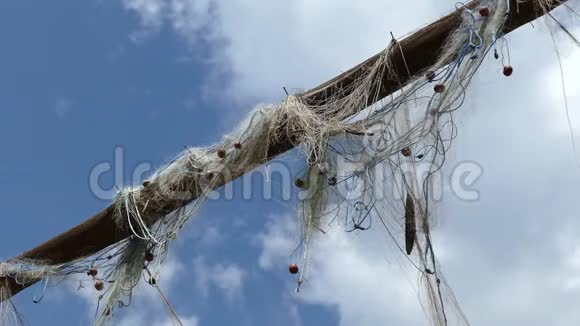 悬挂在木架上的渔网在多云的天空中视频的预览图
