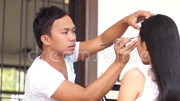 化妆师对一个年轻女人做眉毛视频的预览图