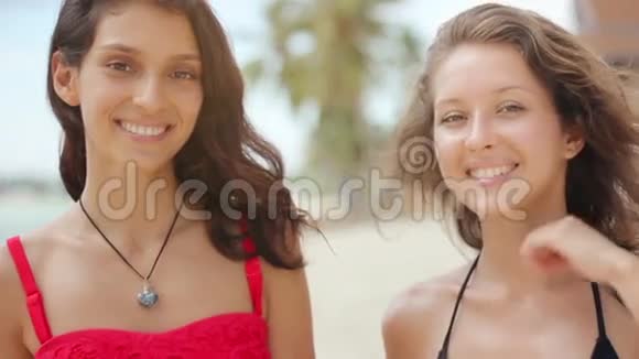 在海滩上迷人的女人在镜头前微笑视频的预览图