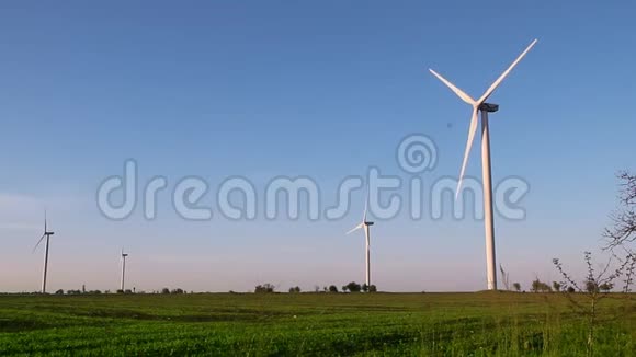 风力涡轮机在日落天空背景下能源发电机自然友好春天的田野视频的预览图